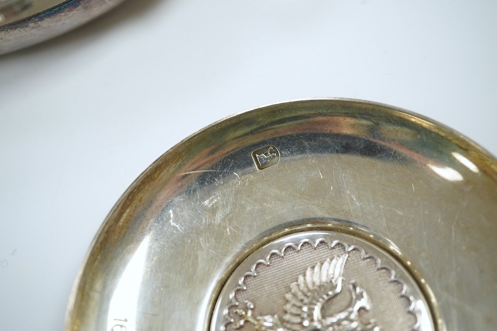 A 1970's Brittania standard silver commemorative small dish, C. Hoare & Co, London, 1972, 92mm, together with a German 925 oval dish with serpent handles and inset with coin, gross 8.9oz. Condition - fair